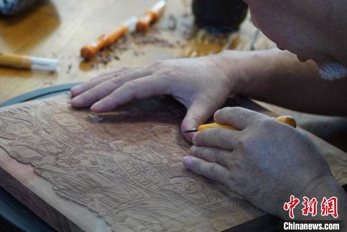 圖為徐晉林湊近木板，近距離制作雕版畫。　九美旦增 　攝