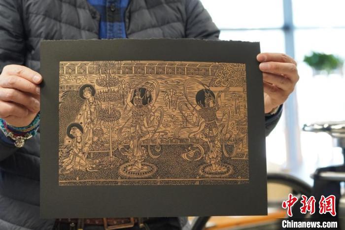 圖為手工書藝人展示敦煌雕版壁畫印刷品。　九美旦增 　攝