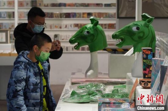 圖為“神馬來了”銅奔馬頭套吸引參觀者駐足?！【琶赖┰?攝