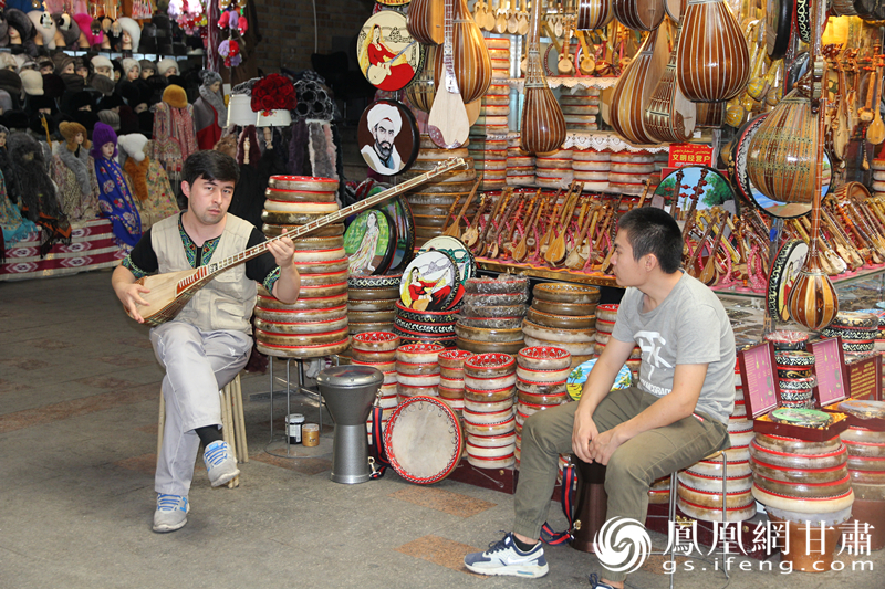 烏魯木齊二道橋巴扎內(nèi)，店主正在向客人展示樂器。楊文遠(yuǎn) 攝