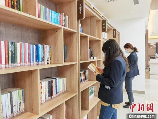 圖為在甘肅公航旅建設(shè)集團(tuán)有限公司的職工書屋，職工挑選書籍?！⌒煅?攝