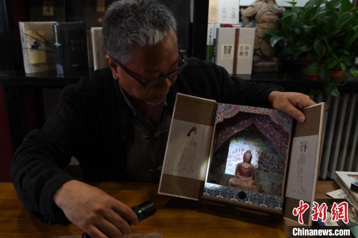 圖為讀者出版集團讀者晉林工作室獨立出品人徐晉林，展示互動性強的敦煌題材手工書。(資料圖) 楊艷敏 攝