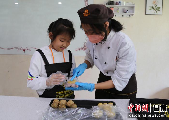 圖為在甘臺胞小朋友在工作人員指導(dǎo)下制作月餅。九美旦增 攝