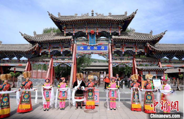 圖為身穿土族服飾的工作人員迎接訪客?！⊙Φ?攝