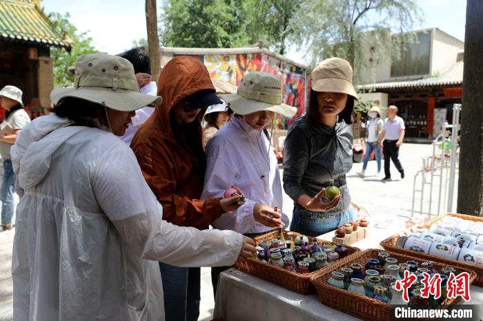 圖為民眾挑選手工藝產(chǎn)品?！⊙Φ?攝