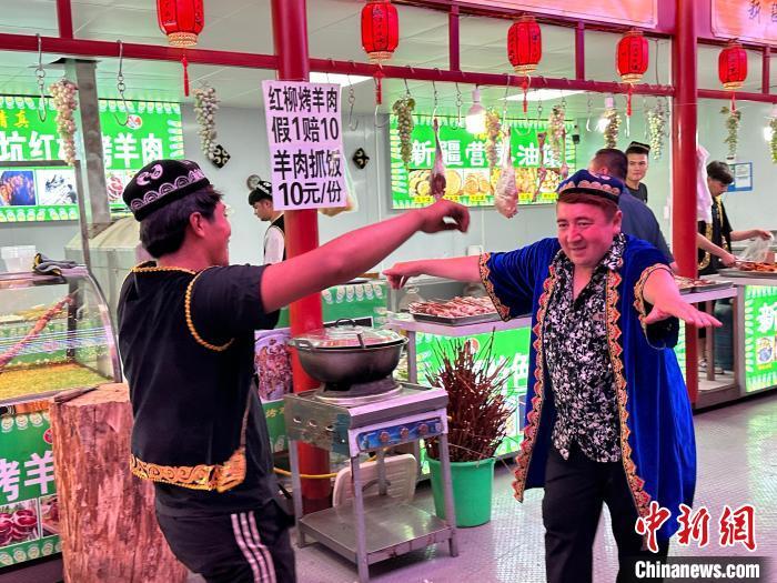 圖為餐飲經(jīng)營(yíng)者在“西涼不夜城”跳起舞蹈引客?！〈魑牟?攝</p><p>