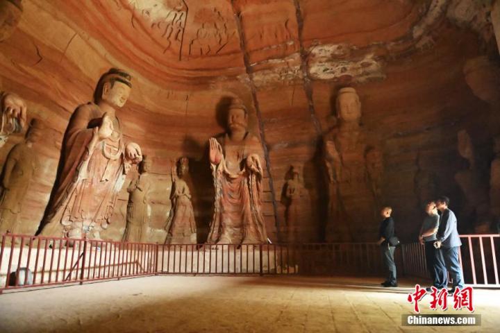 7月15日，游人參觀甘肅省平?jīng)鍪袥艽h百里石窟長(zhǎng)廊中的南石窟寺1號(hào)窟。百里石窟長(zhǎng)廊位于涇川縣境內(nèi)，由512個(gè)石窟、5眼窟中石井組成，現(xiàn)存王母宮石窟、鳳凰山石窟、南石窟寺、丈八寺石窟、羅漢洞石窟、太山寺石窟等規(guī)模較大的石窟群，還有數(shù)量眾多的小石窟群。南石窟寺開(kāi)鑿于北魏永平三年，其中1號(hào)窟屬于大型七佛窟，七佛高達(dá)6米。中新社記者 李亞龍 攝