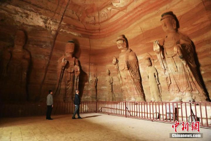 7月15日，游人參觀甘肅省平?jīng)鍪袥艽h百里石窟長(zhǎng)廊中的南石窟寺1號(hào)窟。百里石窟長(zhǎng)廊位于涇川縣境內(nèi)，由512個(gè)石窟、5眼窟中石井組成，現(xiàn)存王母宮石窟、鳳凰山石窟、南石窟寺、丈八寺石窟、羅漢洞石窟、太山寺石窟等規(guī)模較大的石窟群，還有數(shù)量眾多的小石窟群。南石窟寺開(kāi)鑿于北魏永平三年，其中1號(hào)窟屬于大型七佛窟，七佛高達(dá)6米。中新社記者 李亞龍 攝